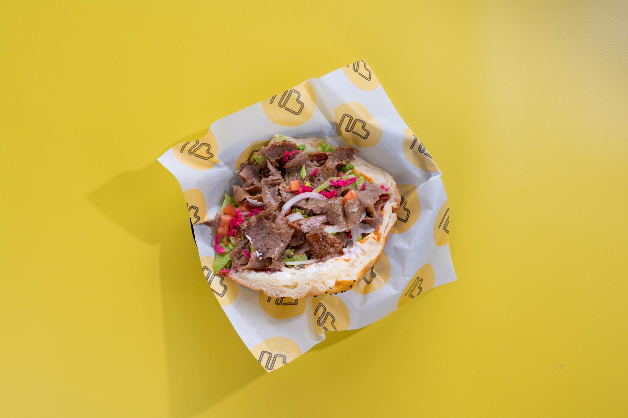 A Berlin-style döner kebab packed with fresh vegetables, seasoned meat, and soft bread, showcasing authentic German food flavors.